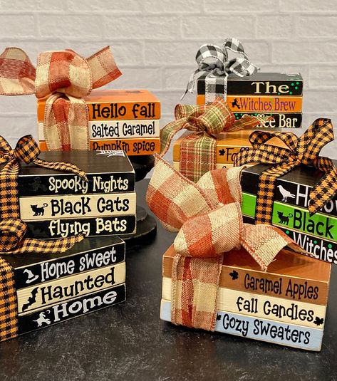 These fun book stacks will look beautiful with your holiday decor.  Made from wood and painted to look like books there is a festive ribbon tied around them and vinyl lettering on each book.  They are sealed with a poly coat sealant. Please choose your style from the drop down menu. Each book stack is approximately 5" x 3.5" x 2.25" Black pedestal in listings is not for sale.  You will receive book stack only. Each stack will come cellophane wrapped and is ready to ship. If you have any questions, please message me. Wooden Book Decor Diy, Dollar Tree Stacked Books, Christmas Wood Books, Fall Stacked Books Diy, Fall Craft Sale Ideas, Fall Book Stack Diy, Mini Book Stacks Diy, Stacked Books Decor Diy Wood, Diy Wood Books