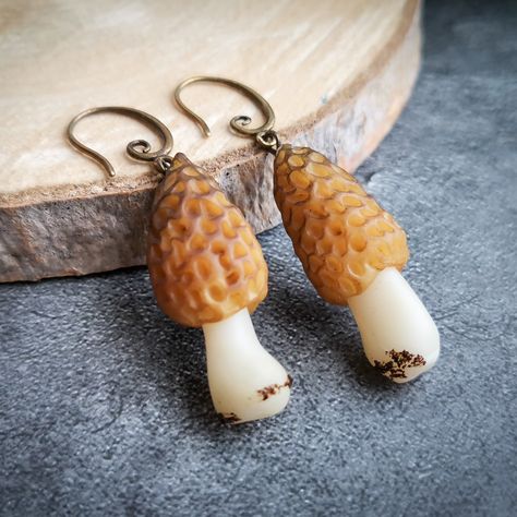 Morel mushrooms earrings are weird, funny, fairy, quirky, earrings. Morel looks real. Mushroom earrings are great fungi coblincore jewelry, gift for her for any occasion.You can order a Morel charm, pendant, or keychain, I will make it for you very quickly. Just write to me and I will create a custom listing.Be the most unique! SIZE: Look at the photo with the ruler. Weight about 2,12g (0,075oz) each earring.Loop earrings made of highquality bijouterie alloy. Loop size: 11 x 19 mm. Color: bronze Mushrooms Earrings, Funny Fairy, Moana Necklace, Merry Mushroom, Cottagecore Earrings, Morel Mushrooms, Cottagecore Jewelry, Weird Funny, Mushroom Jewelry