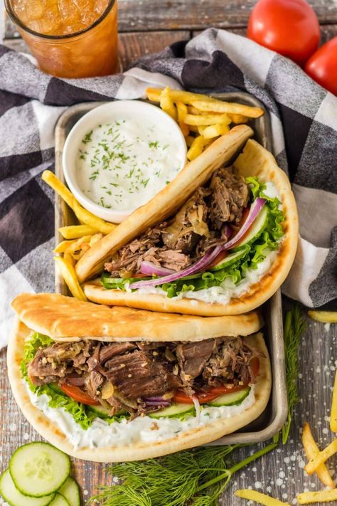 These Slow Cooker Gyros are an easy and tasty spin on classic Greek gyros. Made with juicy and flavorful chuck roast, tender onions, and a dreamy homemade tzatziki sauce, this recipe is guaranteed to be a crowd favorite. Recipes With Beef Chuck Roast, Slow Cooker Gyros, Slow Cooker Round Roast, Beef Chuck Recipes, Lamb Gyro Recipe, Beef Gyro, Lamb Gyros, Greek Gyros, Gyro Recipe