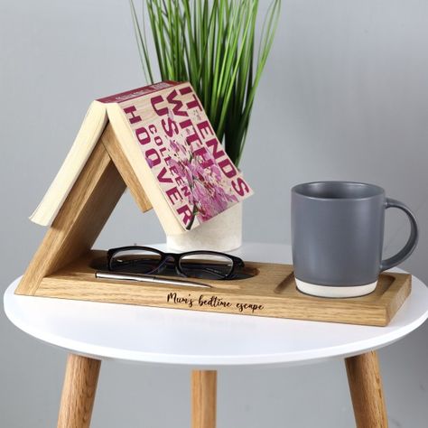 A personalised book rest in solid oak designed to sit by the bedside or desk and make the perfect gift for a avid book lover with leather lined glasses tray, coaster and pen holder.Our bookmark book stand will make the perfect Mother's Day gift or Father's Day, birthday or 5th wooden wedding anniversary gift. For any bookworm especially someone for who loves a good book before going to bed.The personalised touch makes it a truly unique and thoughtful present. Engrave a heartfelt message, initials or a special date, creating a bespoke item that resonates with sentimental value. Perfect for a teacher, doctor, religious person (bible stand) or theologist as a graduation gift to celebrate and document a loved one’s achievement.Hand crafted in the UK from high-quality solid oak, this book Wood Book Page Holder, Wooden Ideas Handmade, Book Stands Diy, Wood Projects Aesthetic, Bedside Book Holder, Wood Gifts To Make, Woodworking Gifts For Her, Book Rest Diy, Wood Project Gifts