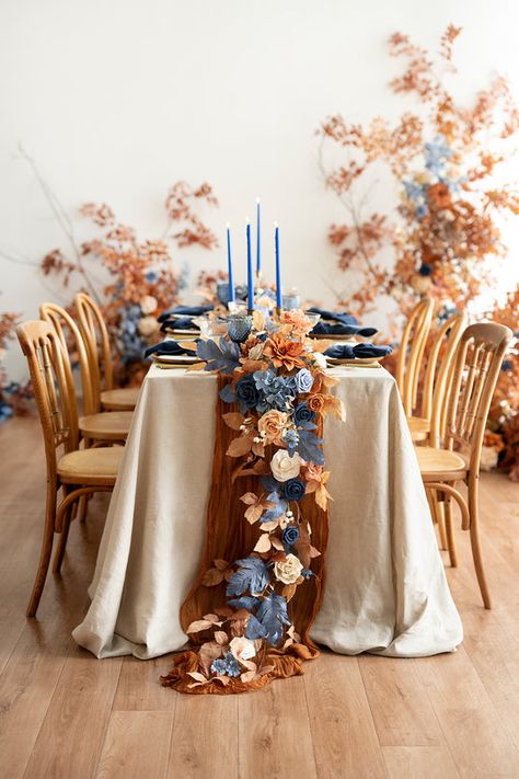 Indulge your free spirit with Ling's Russet Orange & Denim Blue Collection. Warm Orange collides with shades of soft and rich denim blue, creating a rustic palette ideal for fall or barn weddings. Save time on your wedding journey with premade floral arrangements, like bouquets, centerpieces, and arch decor, or exp Marigold And Blue Wedding, Navy And Rust Wedding Table Decor, Long Wedding Table Centerpieces, Country Centerpieces Wedding, June Wedding Centerpieces, Fall Wedding With Blue, Blue And Gold Table Decor, Blue Thanksgiving Table Decor, Dusty Blue And Terracotta Wedding