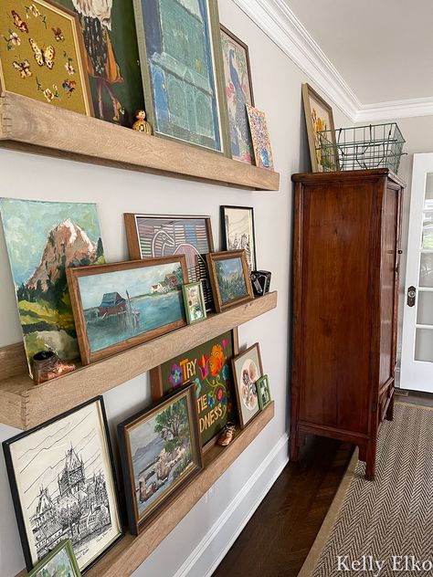 Wall Art On Shelves Picture Ledge, Picture Ledges Living Room, Gallery Wall Inspiration Artwork, Art Studio Room Artwork, Pictures Of Artists At Work, Picture Ledge Wall Hallway, Wall Picture Ledge Ideas, Picture Ledge Above Piano, Decorated Living Room Walls