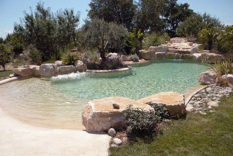 lagoon beach pool- add more tropical plants around, CHLORINE-FREE WATER FILTRATION, UNDERWATER LIGHTS, INTEGRATED WHIRLPOOLS, CASCADES, CURRENT STREAMS, UNDERWATER MUSIC SYSTEMS, WATERFALL AND A SPECIAL FLOOR AND SIDE WALL SURFACE APPLICATION WHICH IS NATURAL SAND BASED TO ACHIEVE THE UNIQUE BEAUTIFUL ORGANIC "BEACH" LOOKING ATMOSPHERE. Underwater Music, Swimming Pool Pond, Beach Entry Pool, Building A Swimming Pool, Natural Swimming Ponds, Pool Finishes, Lagoon Pool, Backyard Beach, Natural Pond