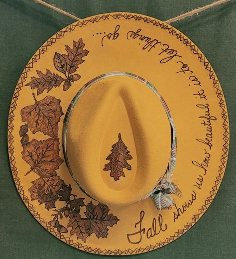 Grab this gorgeous Vegan Suede Mustard colored Fall hat.  "Fall shows us how beautiful it is to let things go".  Burned leaves adorn the top.  Size Medium with an adjustable cord inside. Burnt Hats Designs, Burn Felt Hat, Hat Paintings Ideas, Burnt Felt Hat, Hat Pyrography, Sunflower Burned Hat, Felt Burning, Floral Burned Hat, Hat Making Ideas