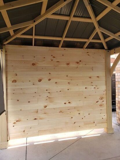 I added a privacy wall/ T.V. to our gazebo by framing up one side of the gazebo and adding pine tongue and groove to the inside. Not only does it create privacy but it's the perfect place for mounting a t.v. , hiding the not so pretty part of our backyard behind it, and blocking the strong winds we get....and it gives the gazebo a cozy feel.Although there are many other ways we could've done this wall, we did it this way for our home, weather and purpose. And we love it. It's getting a… Privacy Gazebo Ideas, Patio Privacy Wall With Tv, Outdoor Patio Tv Wall Ideas, Patio Privacy Wall Ideas, Privacy Wall Ideas, Patio Privacy Wall, Gazebo Bar, Gazebo Side Panels, Gazebo Privacy