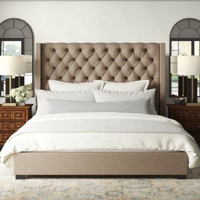 Bring streamlined style to your bedroom or guest room with this upholstered low-profile bed. It’s made of engineered wood with foam padding and 100% polyester upholstery in a neutral brown shade; a tall wingback design and button-tufted detail give this piece a classic, tailored look. This piece comes with slats and center support legs, for added stability; we recommend a 12” thick mattress (sold separately, along with the box spring). This bed completes the look in any traditional or glam setti Brown Platform Bed, Brown Upholstered Bed, Tufted Headboard Bedroom, Tall Bed Frame, Taupe Bedding, Profile Bed, Tufted Upholstered Bed, Tall Bed, Upholstered Bedroom