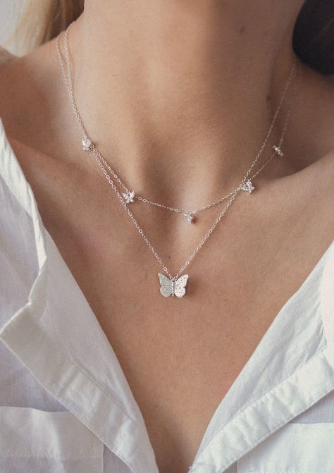 This set consists of 2 sterling silver necklaces, both of which feature butterfly pendants and are fastened at the center back with a round spring clasp, and have a short extension chain. It has: ✅ A delicate chain necklace with a single butterfly pendant attached to the center front of the chain, with intricate detailing on the wings and body ✅ A delicate chain necklace with 5 small butterfly pendants attached to the center front, each pendant made from four zirconia stones.  A dainty and classy duo that will elevate any outfit, including your everyday jeans and tees. Details: ✅ Material: 925 sterling silver, cubic zirconia ✅ Butterfly necklace - length: 42.0 cm (16.53 inches) + 5.0 cm (1.96 inches) length extension; weight: 5.0 g (0.17 oz) ✅ Gemstone multi charm butterfly necklace - leng Womens Necklaces Silver, Butterfly Necklace Silver, Dr Shoes, Pretty Jewelry Necklaces, Small Butterfly, Butterfly Pendant Necklace, Butterfly Jewelry, Fancy Jewelry, Cute Necklace