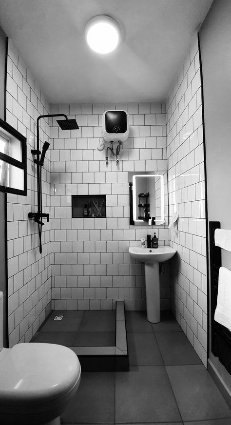 White tiles with black grout, mature black fittings and black towel rail. #Nigeria #Abuja #construction #renovation Toilet Black Tiles, Black Tile Black Grout Bathroom, Small Monochrome Bathroom, White Bathroom Tiles With Black Grout, Black Wet Room, Black Square Tile Bathroom, Bathroom White Tiles Black Grout, Industrial Toilet Design, Old Bathroom Renovation