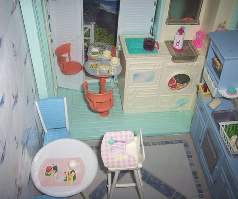 An OOAK beach house kitchen using parts from a Barbie beach house along with a blue kitchen wall unit, recycled nautical wallpaper for walls & vinyl tile for flooring. White folding doors are used as sliding screen doors. The beach background scenes are recycled calendars. Barbie Beach House, Kitchen Wall Unit, Barbie Dollhouse Furniture, 1999 Barbie, Blue Kitchen Walls, Kitchen Wall Units, Barbie House Furniture, Barbie Beach, Dollhouse Rooms