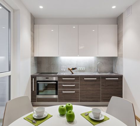 White single wall kitchen featuring a stylish kitchen counter and a small white dining nook. Single Wall Kitchen Layout, One Wall Kitchen Layout, High Gloss Kitchen Cabinets, Single Wall Kitchen, Gloss Kitchen Cabinets, One Wall Kitchen, High Gloss Kitchen, Kitchen Gallery Wall, Small Kitchen Layouts