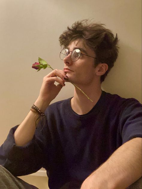 man sat against a white/beige wall in a blue jumper and chequered trousers, holding a rose against their face Charlie Bennett, Haircut Undercut, Barber Style, Undercut Fade, Model Hairstyles, Nerdy Guys, Brown Hair Men, Haircut 2024, Boys Glasses