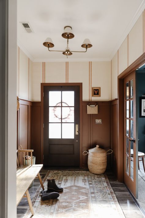 Our Dark and dreary entry got a makeover! We added wallpaper, board and batten (in a fun double stripe pattern!), moody brown paint, a DIY Peg rail, and a brand new door! Dark Wallpaper Entryway Foyers, Entryway Board And Batten With Hooks, Half Wall Entryway Ideas, Front Hallway Ideas Entrance Foyers, Brown Trim White Walls, Hallway Color Ideas, Entryway Paint Ideas, Painted Trim Darker Than Walls, Dark Entryway Ideas