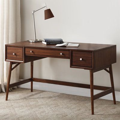 The design of the writing desk allows for the perfect placement within your home/office to accent your busy lifestyle. The brown finish combined with polished nickel knob hardware, drawer storage, and a mid-century-inspired profile, blend effortlessly to create this stylish table. | Corrigan Studio® Gavian Desk Wood in Brown | 30 H x 51.24 W x 24 D in | Wayfair Home Office Desks With Drawers, Simple Dark Wood Desk, Brown Desk Accessories, Vintage Desk Ideas, Desk Under Window, Dark Walnut Desk, Desk Dark Wood, Dark Brown Desk, Dark Wooden Desk