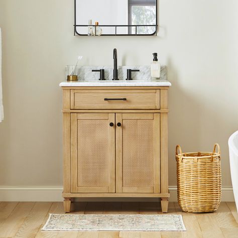 Infuse coastal chic into your bathroom with the allen + roth Wallister 30-inch bathroom vanity. Wallister pairs classic caning with a natural oak wood finish to deliver a beautiful centerpiece to your bathroom. The cabinet features a solid wood frame and 2 reversible soft-closing doors, so it’s easy to change the look from coastal to traditional. A tilt-down drawer, adjustable shelf, and power outlet provide abundant storage and convenience. The Natural laminated Carrara white marble top comes with a pre-installed rectangular sink and is pre-drilled for an 8-in widespread faucet. This smaller vanity is perfect for a guest or powder room, but Wallister is also available in a larger 48-in profile for bigger bathrooms. allen + roth Wallister 30-in Wood Undermount Single Sink Bathroom Vanity w 35 Inch Bathroom Vanity, Small Simple Bathroom Remodel, 27 Inch Bathroom Vanity, Light Wood Bathroom Vanity Single Sink, Small Bathroom Vanity With Storage, Small Bath Vanity Ideas, 30in Bathroom Vanity, Small Bathroom Inspiration Decor, Black And White Bathroom With Wood Vanity