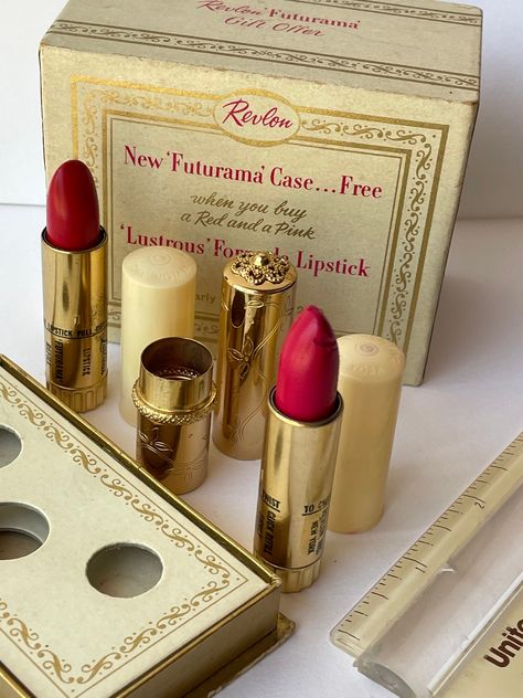 This is a RARE unused Futurama lipstick store display boxed set with 2 full lipsticks and the gorgeous and glamorous golde, Futurama lipstick case!  The two red refill lipsticks are the infamous "Cherries in the Snow" and "Love that Red!" These gorgeous vintage lipsticks are unused, full, fully Twistable and retain their original color shade labels on the bottom. Cherries in the Snow lipstick itself has some tip mishaps near the top; as shown. Remarkable vintage condition!   The golden lipstick tube is flawless. The top of the cardboard box reads: "Revlon Futurama Gift Offer."  These are very rare as a store (Revlon Futurama Gift Offer.") display set and highly collectible for the makeup history enthusiasts! If your've worn lipstick, even in mid-century, you may be familiar with Revlon's f Retro Beauty Packaging, 50s Makeup Products, Vintage Makeup Packaging, Golden Lipstick, Aqua Tofana, Cherries In The Snow, Lipstick Packaging, Snow Love, Makeup History