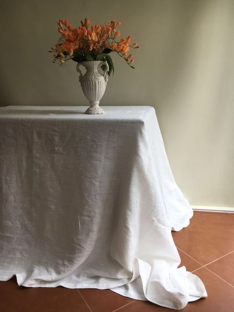 "A true classic. White linen tablecloth in a stunning medium weight with the beautifully distinct linen texture.  Made from 100% pure linen it will be a fantastic addition to your table. Drapes beautifully. Classic quality. Dress your table up for special events or enjoy the simple touch.  Layer with another tablecloth in natural taupe for a stylish look.  Available in various sizes. We can also make a round tablecloth with maximum 54\" in diameter.  Please allow for ONE week to hand-tailor the White Linen Table Cloth, Small Apartment Table, White Linen Table, White Linen Tablecloth, Modern Tablecloths, Dark Wood Table, Linen Table Cloth, Breakfast Nooks, White Tablecloth