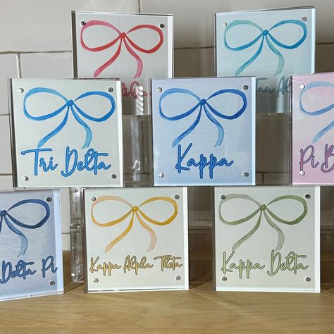 Show your sorority pride with this cute acrylic block with a trendy bow design in your sorority's colors! This  fun design makes a great gift for bid day, big/little reveal or a special gift for any sorority sister. ~TO ORDER~ Choose your sorority from the drop-down list.  ~ PRODUCT DETAILS ~ 4" x 4" x .8" acrylic block Two acrylic pieces with magnets to hold together Custom sorority print inserted between blocks ~ OTHER INFORMATION ~ Normal turnaround varies by item and is indicated in the shipping information. See shop announcement for variations. If you need an item sooner, please send a message before placing your order.  Happy Thoughts Gifts is a Greek-licensed provider. Only the sororities shown are currently licensed. For a wide selection of gifts, please visit my personalization sh Big Little Diy Gifts, Sorority Big Little Baskets Ideas, Sorority Reveal Boxes, Sorority Gift Ideas, Big Little Canvas Sorority, Sorority Wooden Letters, Big Little Baskets, Big Little Baskets Ideas, Sorority Big Little Baskets