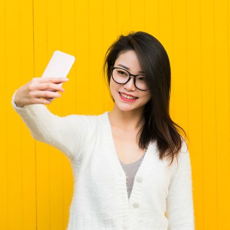 Woman takes selfie of herself in front of yellow wall Kawaii, Taking Selfies Poses Drawing, Taking Selfie Pose Reference Drawing, Taking Selfie Reference, Hand Props, Woman Taking Selfie, Selfie Studio, Inspired Images, Taking Selfie