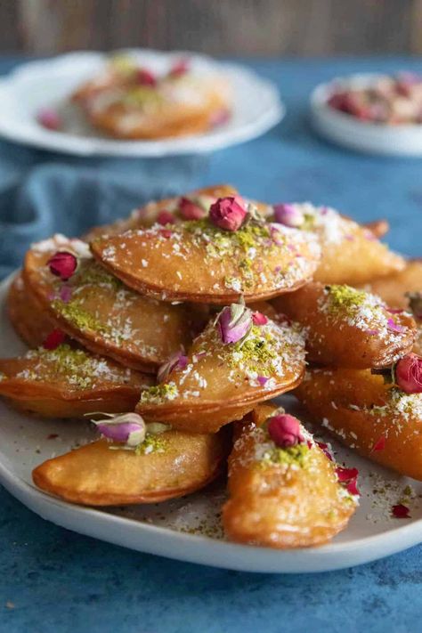 Qatayef is a Middle Eastern dessert served during the month of Ramadan. It's made of pancakes stuffed with nuts or cream, fried and then soaked in syrup. These pancakes are always topped or soaked in simple syrup before serving. Qatayef is popular year-round but is especially enjoyed for Iftar during the month of Ramadan. Date Filled Cookies, Maamoul Recipe, Middle Eastern Dessert, Arabic Desserts, Middle Eastern Desserts, Sweet Dumplings, Dairy Desserts, Persian Cuisine, Month Of Ramadan