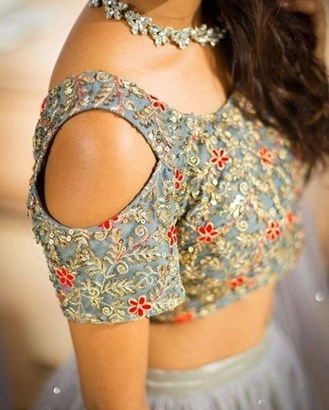 Love this cold shoulder blouse cut | Grey Blouse with gold and red embroidery | Bridal Outfit Ideas | Blouse Design | Indian Wedding Ideas | Credits: Saved from Instagram | Every Indian bride’s Fav. Wedding E-magazine to read. Here for any marriage advice you need | www.wittyvows.com shares things no one tells brides, covers real weddings, ideas, inspirations, design trends and the right vendors, candid photographers etc. Cold Shoulder Saree Blouse, Cold Shoulder Blouse Designs, Saree Jacket Designs, Latest Saree Blouse, Cl Fashion, Latest Bridal Blouse Designs, Blouse Designs Catalogue, Lehenga Blouse Designs, Sari Blouse Designs