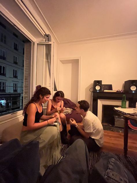 friends sitting at a window, teenagers aesthetic, french student lifestyle, paris aesthetic, paris by night, trio, parisian apartment, amelie poulain vibes Working In Paris, Study In Paris, Paris Student Aesthetic, Roomates Aesthetics, Paris Teenager, Student Apartment Aesthetic, French Apartment Aesthetic, Paris Apartment Aesthetic, Diff Aesthetics