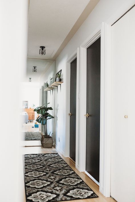 Black doors contrast white hallway Hallway Decorating Black Doors, Black Interior Hall Doors, Black Door Hallway Decor, Black Doors And White Walls, White Hall Black Doors, Hall With Black Doors, Black Indoor Doors Bedroom, Black Hall Doors, White Hallway With Black Doors