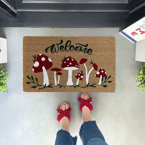 "Our mushroom doormat doormat is the perfect way to create an inviting and charming entry way or makes a great housewarming gift for any plant lover! Featuring red and white mushrooms and dark green text and leaves this mushroom doormat is bright and bold!   ✦Production time is 5-7 business days prior to shipping. Shipping is UPS Ground or USPS service. No PO Boxes, please. ✦All our coir welcome mats are natural brown in color. Minor variations are normal. ✦This doormat is standard size, 18x30 inches and approx. .65 inches thick. ✦The natural coir fibers of the doormat are from coconut husks which is mildew resistant and they have an extra-sturdy, thick vinyl backing to keep them in place. ✦Your doormat is UV printed with permanent UV cured ink. We print each of our original designs at our Painting Coir Doormat Diy, Diy Welcome Mat Paint, Cute Doormat Ideas, Mushroom Doormat, Diy Doormat Paint, Funny Door Mats, Painted Outdoor Rug, Diy Doormat Ideas, Welcome Mat Ideas