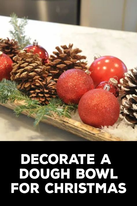 How to Decorate a Dough Bowl for Christmas How To Decorate With Dough Bowls, How To Decorate A Wooden Trough, Wooden Dough Bowl Christmas Centerpiece, Ornaments In Dough Bowl, Ornaments In Bowl Decor, How To Style A Dough Bowl For Christmas, Dough Bowl Decor Christmas, Christmas Decor Dough Bowl, Wooden Bowl Decor Ideas Rustic