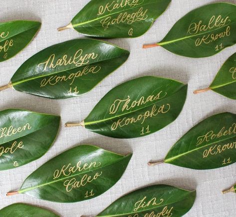 gold calligraphy magnolia leaf for escort card Magnolia Leaf Wedding, Leaf Seating Cards, Leaf Seating Chart, Wedding Seating Charts, Leaves Name, Calligraphy Table Numbers, Elegant Wedding Ideas, Magnolia Leaf, Gold Calligraphy