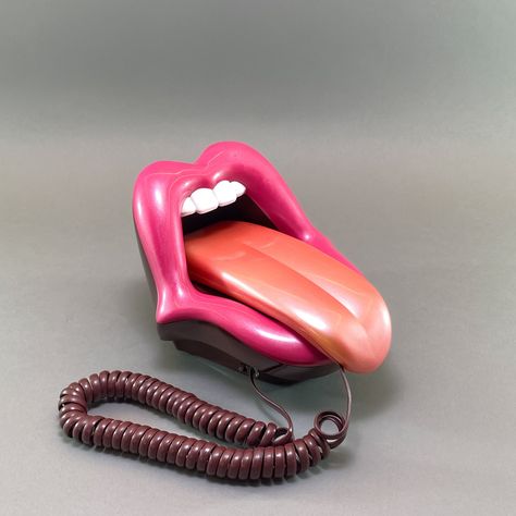 Add a quirky touch to your space with this unique 1990s Pop Art Mouth Telephone! 👄📞 This whimsical landline phone, designed to resemble a mouth with a tongue as the handset, is sure to be a conversation starter. Perfect for collectors and fans of quirky decor, this rare find is fully functional and in mint condition. Imagine the fun and flair it will bring to your home or office! Key Features: 📞 Novelty Landline Telephone - Eye-catching mouth and tongue design. 🏠 Retro Home Decor - Adds a playful and artistic element to any space. 🌟 Collectible - Highly collectible, especially for those who love unique and retro items. ✨ Mint Condition - Pristine condition, fully functional. 🎁 Unique Gift - Ideal for those who appreciate rare and quirky items. 🌍 International Free Express Shipping - Quirky Vintage Home Decor, Weird Accessories Unique, Pop Art Mouth, Pop Art Office, Nostalgic Decor, Art Mouth, Telephone Retro, Kitschy Decor, Novelty Decor