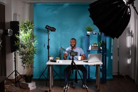 Premium Photo | Blogger connecting with subscribers while speaking in microphone and live streaming in studio Smiling african american vlogger looking at professional camera while recording video Sitting At Desk, Home Recording Studio Setup, Recording Studio Setup, Recording Video, Video Backdrops, Streaming Setup, Home Recording Studio, Creator Studio, Professional Camera