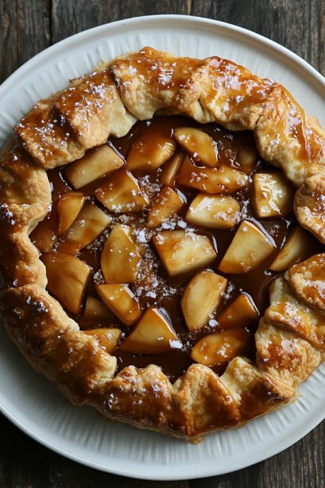 Indulge in a delectable rustic salted caramel apple galette, featuring a flaky crust filled with sweet apples and topped with warm caramel. Perfect for dessert lovers, this delightful recipe mixes comforting flavors with seasonal ingredients. The pin includes one image showcasing this stunning pie. Caramel Apple Galette Southern Living, Salted Caramel Apple Galette, Apple Pie Crust Ideas, Apple Galette With Pillsbury Pie Crust, Caramel Apple Galette, Apple Galette Recipe, Apple Tartlets, Apple Tarte, Apple Tarts