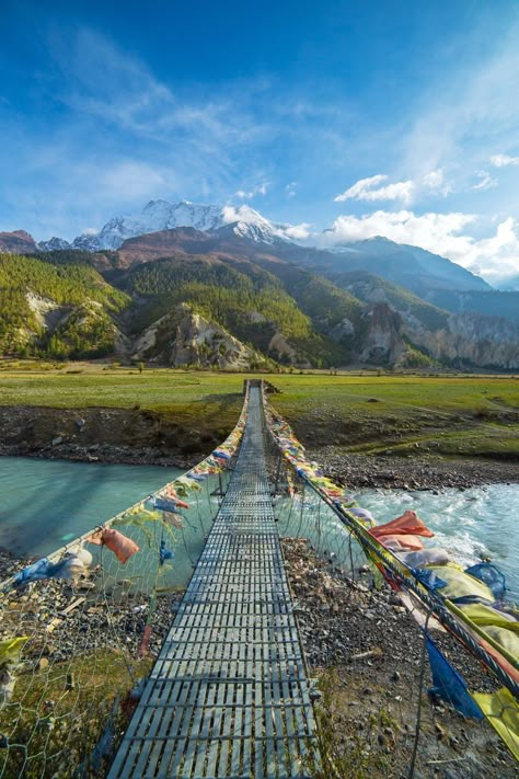 A suspension bridge leads the way to the Annapurna Circuit in Nepal.  ©️️Alexander Mazurkevich Nepal | Travel | Honeymoon | Backpack | Backpacking | Vacation South Asia | Budget | Off the Beaten Path | Trekking | Bucket List | Wanderlust | Things to Do and See | Culture | Food | Tourism | Like a Local | #travel #vacation #backpacking #budgettravel #offthebeatenpath #bucketlist #wanderlust #Nepal #Asia #southasia #exploreNepal #visitNepal #seeNepal #discoverNepal #TravelNepal Monte Everest, Nepal Culture, Travel Nepal, Annapurna Circuit, Backpacking Asia, Nepal Travel, Suspension Bridge, Destination Voyage, Base Camp