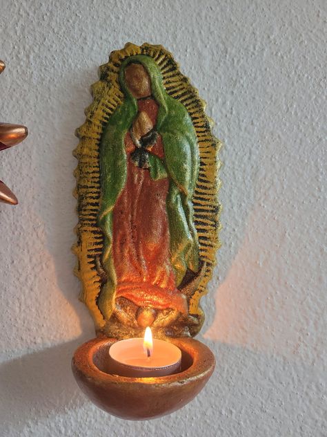 Virgen de Guadalupe Hecha de Barro Virgen candle holder with hock on the back made of clay perfect for indoors and  outdoors La Virgen de Guadalupe (Our Lady of Guadalupe) This beautiful art piece is hand-made in Guadalajara Jal. Our Virgen is an eye-catching addition to any wall inside and the outdoor safe can hold a tealight candle You will fall in love instantly with this stunning figurine--the perfect gift choice for your loved ones for all occasions especially December 12. (Dia de la Virgen de Guadalupe) Hecha por la tia Dona Trini con mucho amor  (7 1/2 IN H) (4 IN W) Made out of light mud clay (Barro) For better prices -------> WWW.ARTEAREGIN.COM <------------ WHOLESALE PRICES AVAILABLE We ask you to PLEASE understand ALL our art pieces are 100% HANDMADE with LOVE and might have min Mexican Rustic Bedroom, Chicana Home Decor, Frida Decor, Mexican Ceramics Pottery, Our Lady Of Guadalupe Altar Decorations, Virgin Mary Altar, Guadalupe Altar, Mexican Catholic Art, Mexican Pottery Decor