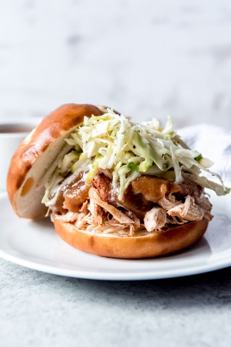 Tender, fall-apart chicken with a warm, spiced applesauce barbecue sauce and crispy apple cabbage slaw on soft pretzel buns make these Slow Cooker Applesauce Pulled Chicken Sandwiches THE sandwich for fall! #sandwich #slowcooker #crockpot #chicken #pulledchicken #easy #apples #applesauce #sliders Fall Sandwich, Apple Cabbage Slaw, Oven Fried Pickles, Apple Cabbage, Pork Chop Sandwiches, Spiced Applesauce, Pretzel Buns, Slow Cooker Applesauce, Pulled Chicken Sandwiches