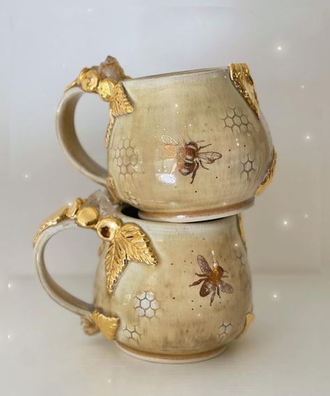 Lauren Lewis on Instagram: "These mugs are begging to be used for a cup of hot tea with honey as the weather turns cool. 🍂🍯🐝 . . . #clay #handmadehome #honeybee #potterymaking #pottery #ceramicart #ceramic #honeycomb #bees #beeswax #beekeeping #beeart #artistsupport #intentionalart #designinspo #honey #honeybees #cottagecore #boho #crystals #citrine #cottagecoreaesthetic #quartz #cottagegarden #maker #naturewitch #witchyvibes #mug" Bee Clay Mug, Ceramic Bee Mug, Honey Comb Pottery, Bee Hive Pottery, Bee Ceramics Pottery, Cottagecore Ceramics, Beehive Pottery, Ceramic Bees, Bee Ceramics