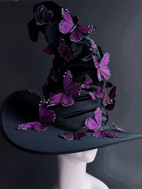 Transform your Halloween costume into a bewitching masterpiece with our black witch hat. This hat is adorned with beautiful purple butterflies that dance in the moonlight, adding an enchanting touch to your look. Whether you're brewing potions, casting spells, or just looking to turn heads, this hat will add an extra layer of magic to your ensemble. Age Group/Gender - Adult/Unisex Size/Type - One size fits all adults Hat Base Color - Black Hat Material - Fabric Witch Hat Alternative, Unique Witch Hat, Purple Hair Witch Costume, Witch Costumes Purple, Butterfly Witch Costume, Cool Witch Hats, Black Butterfly Costume, Custom Witch Hat, Witches Hats Decorations