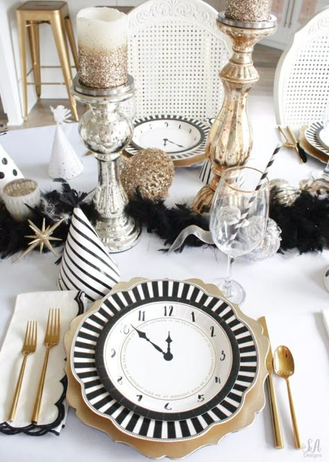 black white gold tablescape, black and white striped graces dinner plates, gold chargers, crystal chandelier, clock plates new years eve, new years eve game, new years eve food, mercury glass candlesticks, sugar paper la white black scalloped dinner napkins, party hat, mercury glass candlesticks, glitter candles New Year’s Eve Place Setting, New Years Place Setting, New Years Table Centerpieces, New Years Brunch Decorations, New Year’s Eve Tablescape, New Year’s Eve Table Setting, New Years Centerpiece Ideas, New Years Table Decor, New Years Eve Tablescape