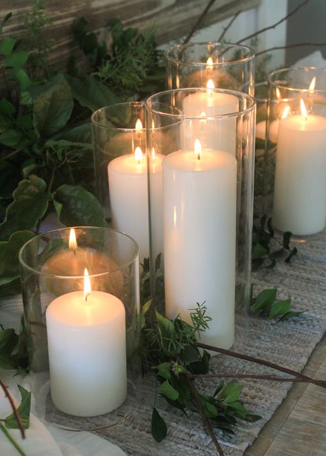 A simple combination of white pillar candles and foliage make a classic Christmas table decoration. Featured 7cm wide Event Pillar Candles in glass vases by www.candleco.com.au Candles In Glass Vases, Tall Candle Holders Decor Ideas, Coffee Table Candle Centerpiece, Big Candle Holder, Seasonal Branches, Wedding Table Styling, Candle Centrepiece, Pillar Candles Wedding, Cylinder Candle Holders