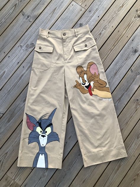 Handpainted Tom&Jerry Overall Painting Ideas, Art Jeans Paintings, Painting Clothes Aesthetic, Paint Pants Ideas, Pant Painting Ideas, Jeans Painting Ideas Aesthetic, Custom Clothes Aesthetic, Drawing On Jeans Ideas, Paint On Pants