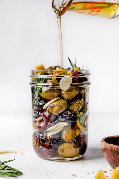 The easiest Marinated Olives recipe! A delicious blend of Italian & Greek olives marinates in olive oil infused with fresh herbs, lemon & garlic. These Italian marinated olives are perfect for everyday snacking, holiday entertaining, all of your charcuterie & cheese boards, or to offer as a showstopping hostess gift. With just 7 simple ingredients & 10 minutes of prep, making marinated olives at home couldn't be easier! #marinatedolivesrecipe #homemademarinatedolives #hostessgiftideas #... Predinner Snacks, Olive Marinade, Marinated Olives Recipe, Foodiecrush Recipes, Platter Boards, Marinated Veggies, Easy Holiday Snacks, Aip Snacks, Cooking Therapy