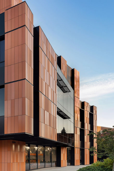 The building counters the tech industry's minimalist, austere aesthetic with a warm, welcoming environment for students and faculty. It features a unique design with a single alveolar ceramic panel, created in eight variations: scratched or smooth, and unglazed, matte, or gloss finish. @gresmanc  #architonic #architecture #facade #exteriordesign #facadedesign #exterior #facadesystem #modernarchitecture #buildingdesign #buildingelements Exterior Commercial Building Design, Industrial Architecture Facade, Austere Aesthetic, Concrete Panel Facade, Office Building Facade, Industrial Building Facade, Commercial Building Exterior, Ceramic Facade, Panel Facade