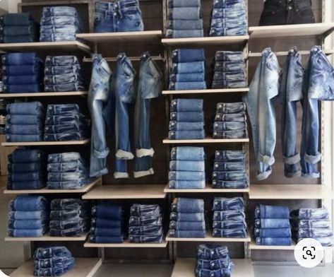 This denim wall is very aesthetically pleasing. They have different colors and styles out that match so well together and stand out against the plain wall and shelves. Jeans Display Ideas, Small Clothing Store Interior, Denim Wall, How To Fold Jeans, Denim Jacket Trend, Denim Display, Fashion Business Plan, Boutique Store Displays, Visual Merchandising Fashion