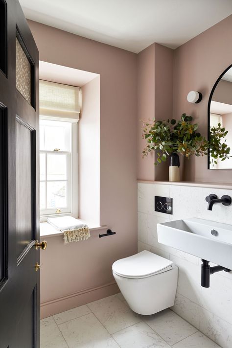 Dusty pink bathroom with contrasting black tapware. Marble tiles and a feature mirror and wall light. Pretty styling and greenery Blush Colored Bathroom, Dusky Pink Bathroom, Pink Downstairs Toilet, Rose Pink Bathroom, Mauve Bathroom Ideas, Dusty Rose Bathroom, Pale Pink Bathroom, Blush Pink Bathroom, Mauve Bathroom