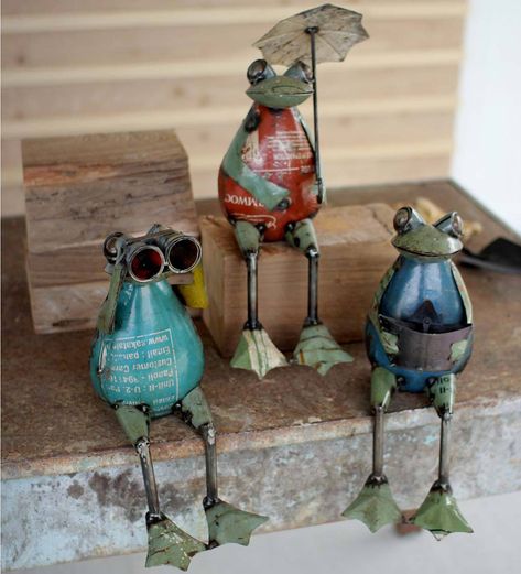 Add a touch of whimsy to your indoor or outdoor spaces with this set of three Recycled Metal Frogs. Handcrafted from reclaimed metal, your set includes three delightful amphibians in a seated position: one with an umbrella, one gazing through binoculars and one enjoying a favorite book. Outdoor Shelf, Outdoor Shelves, Scrap Recycling, Frog Statues, Frog Figurines, Art Shelves, Frog And Toad, Scrap Metal Art, Scrap Metal