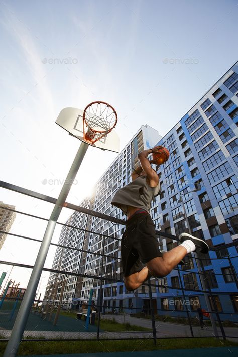 Basketball Player Jumping Action Shot by seventyfourimages. Low angle action shot of African basketball player jumping while shooting slam dunk in outdoor court, copy space #AD #angle, #seventyfourimages, #action, #African Camera Shots And Angles, Basketball Shot, Low Angle Shot, Basketball Shooting, Basketball Photos, Action Photography, Basketball Photography, Low Angle, Camera Shots