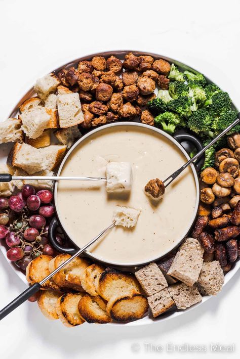 This cheese fondue is creamy, smooth, and by far the best! It's classic melted gruyère cheese flavored with caramelized shallots, apple brandy, and warm spices. It's an easy recipe that's perfect for seasonal gatherings, and it's ready in just 35 minutes! #theendlessmeal #fondue #cheesefondue #gruyerefondue #cheese #gruyere #gruyerecheesefondue #dinner #appetizer Cheese Fondue Platter, Christmas Cheese Fondue, Fondue Ideas Cheese, Cheese Fondue Board, Christmas Fondue Party Ideas, Vegetarian Fondue, Fondue Sides, Fondue Cheese Recipe, Cheese Fondue Dippers Ideas