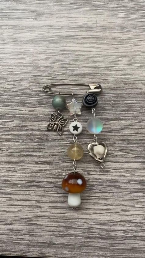 Backpack Safety Pins, Homemade Pins To Wear, Aesthetic Etsy Finds, Black Backpack Decoration Ideas, Safety Pin Backpack Charm, Diy Pins Ideas, How To Make Charms, Safety Pin Bag Charm, Diy Pins For Backpack