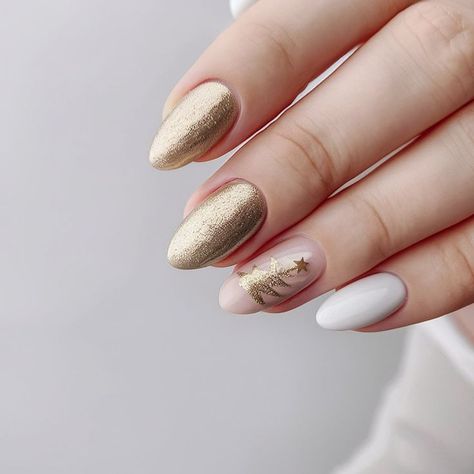 This elegant nail design combines matte white nails with gold accents, featuring a delicate Christmas tree on an accent nail. The shimmering gold nails add a luxurious touch, contrasting beautifully with the simplicity of the white. This design is perfect for those who prefer a refined and understated holiday look that still captures the festive spirit. Accent Nails, White Holiday Nails, Nails With Gold Accents, White Nails With Gold, Nails With Gold, Elegant Nail, Elegant Nail Designs, Accent Nail, Holiday Looks