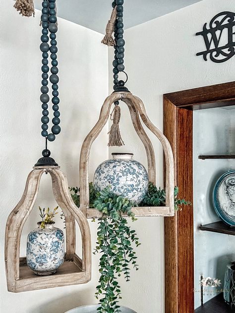 14 Best Decorations That Hang From Your Ceiling Hanging Decor Ideas From Ceiling, Hanging Decor Ceiling, Wood Lantern Decor Ideas, Rustic Hanging Decor, Hanging Items From Ceiling, What To Hang From Ceiling, Boho Hanging Candle Holders, Corner Hanging Decor, Boho Ceiling Hanging Decor